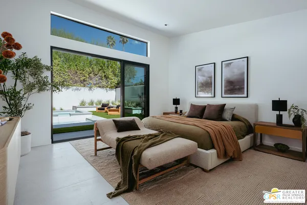 a bedroom with bed and a large window