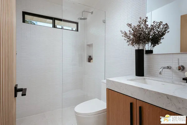 a bathroom with a sink a toilet and shower