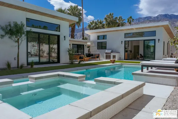 a view of a house with swimming pool and a yard