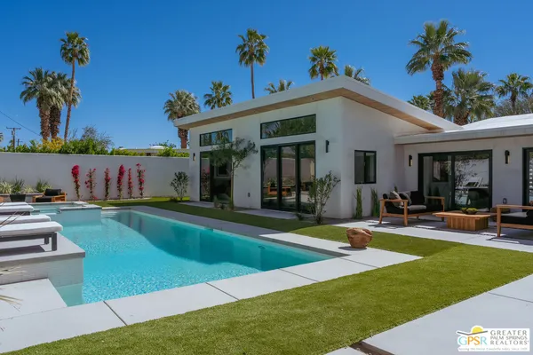 a view of a house with swimming pool and sitting area