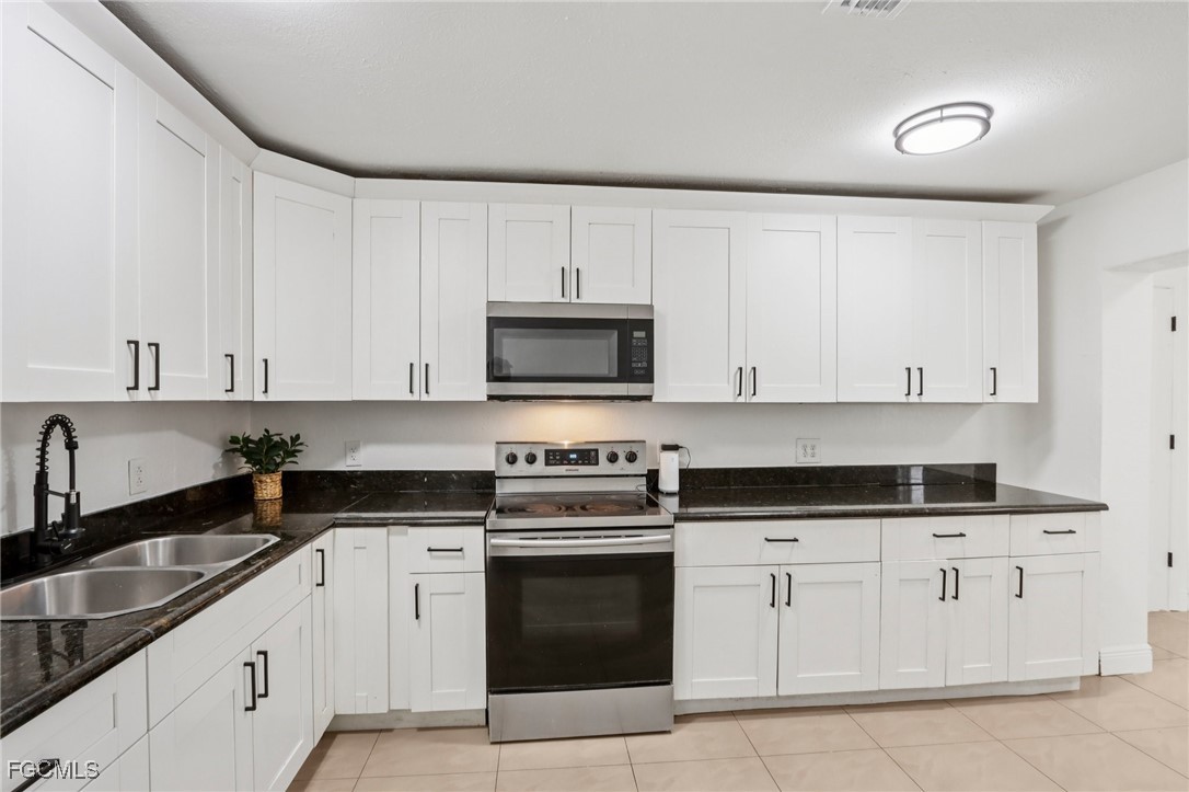 89 Cabana Avenue North Fort Myers, FL 33903 - Photo 3 of 29 a white kitchen with granite countertop white cabinets and a stove top oven