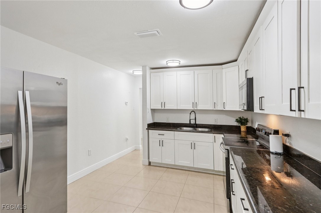 89 Cabana Avenue North Fort Myers, FL 33903 - Photo 4 of 29 a kitchen with stainless steel appliances granite countertop a stove a sink and a refrigerator
