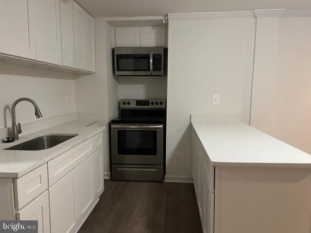 908 Chatsworth Drive Accokeek, MD 20607 - Photo 6 of 24 a kitchen with stainless steel appliances a stove a microwave and white cabinets