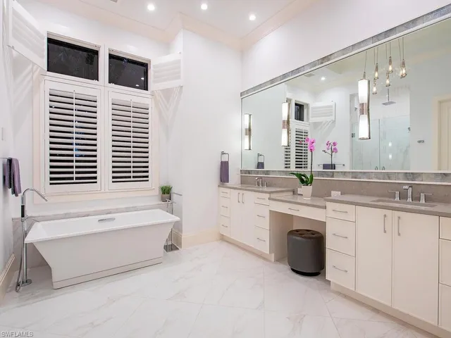 a spacious bathroom with a large tub sink and mirror