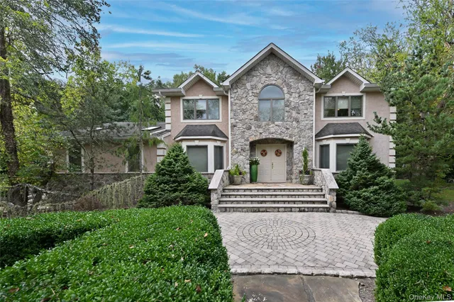 a front view of a house with a yard and trees