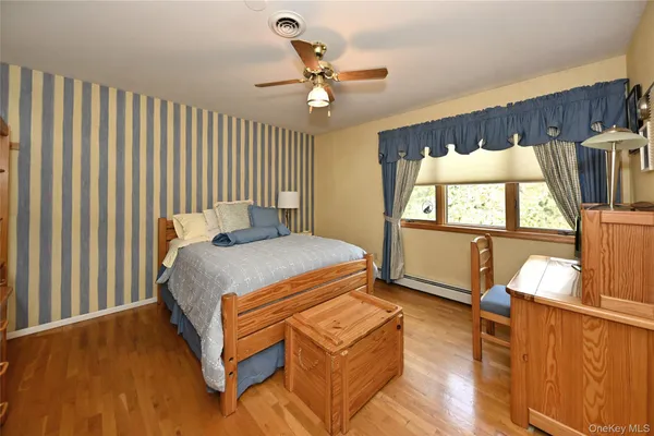 a bedroom with a bed and a wooden floor