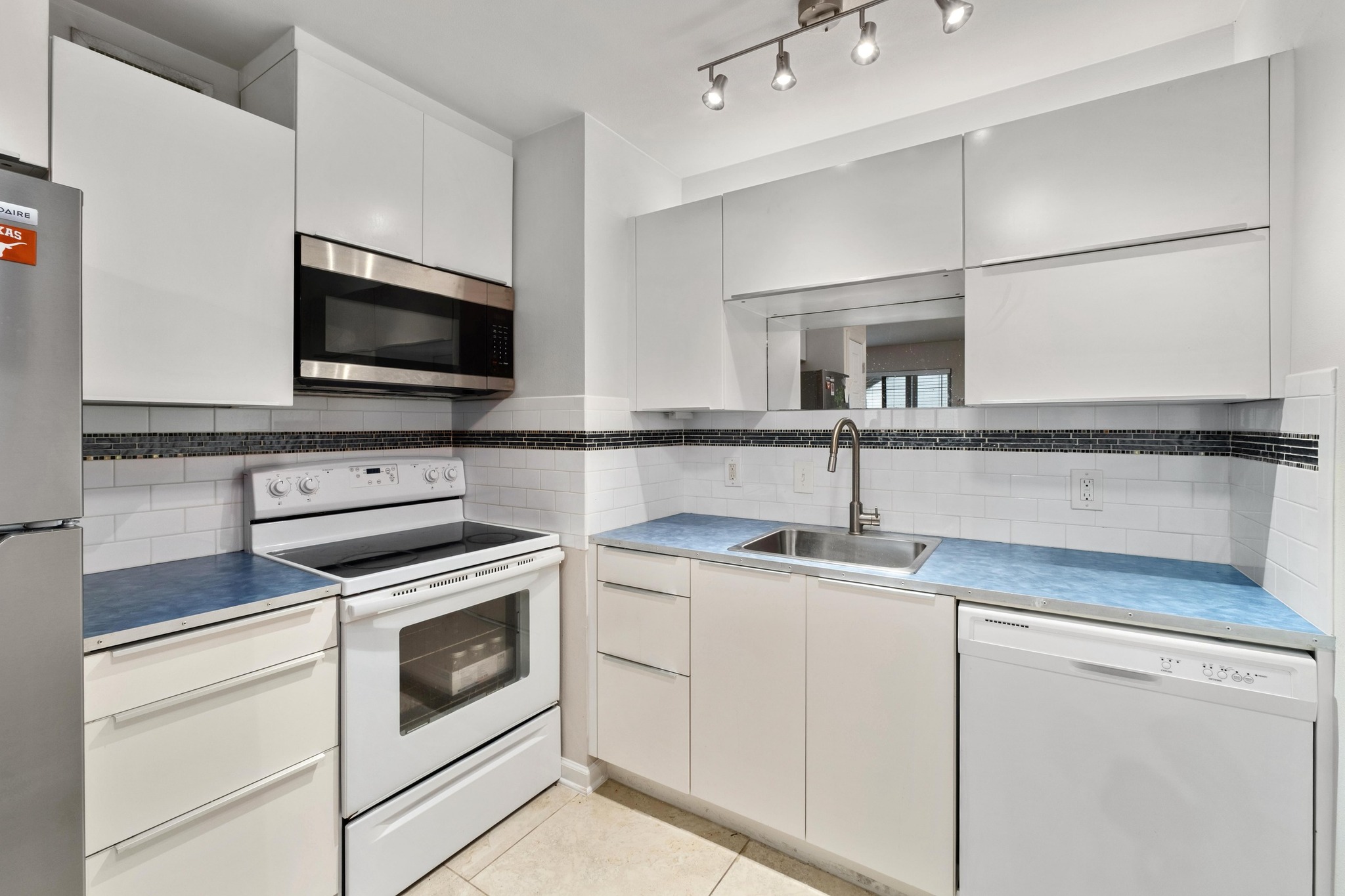 a kitchen with appliances a sink and cabinets