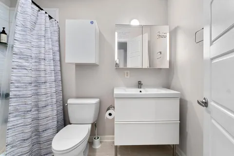 a white toilet sitting next to a bathroom sink
