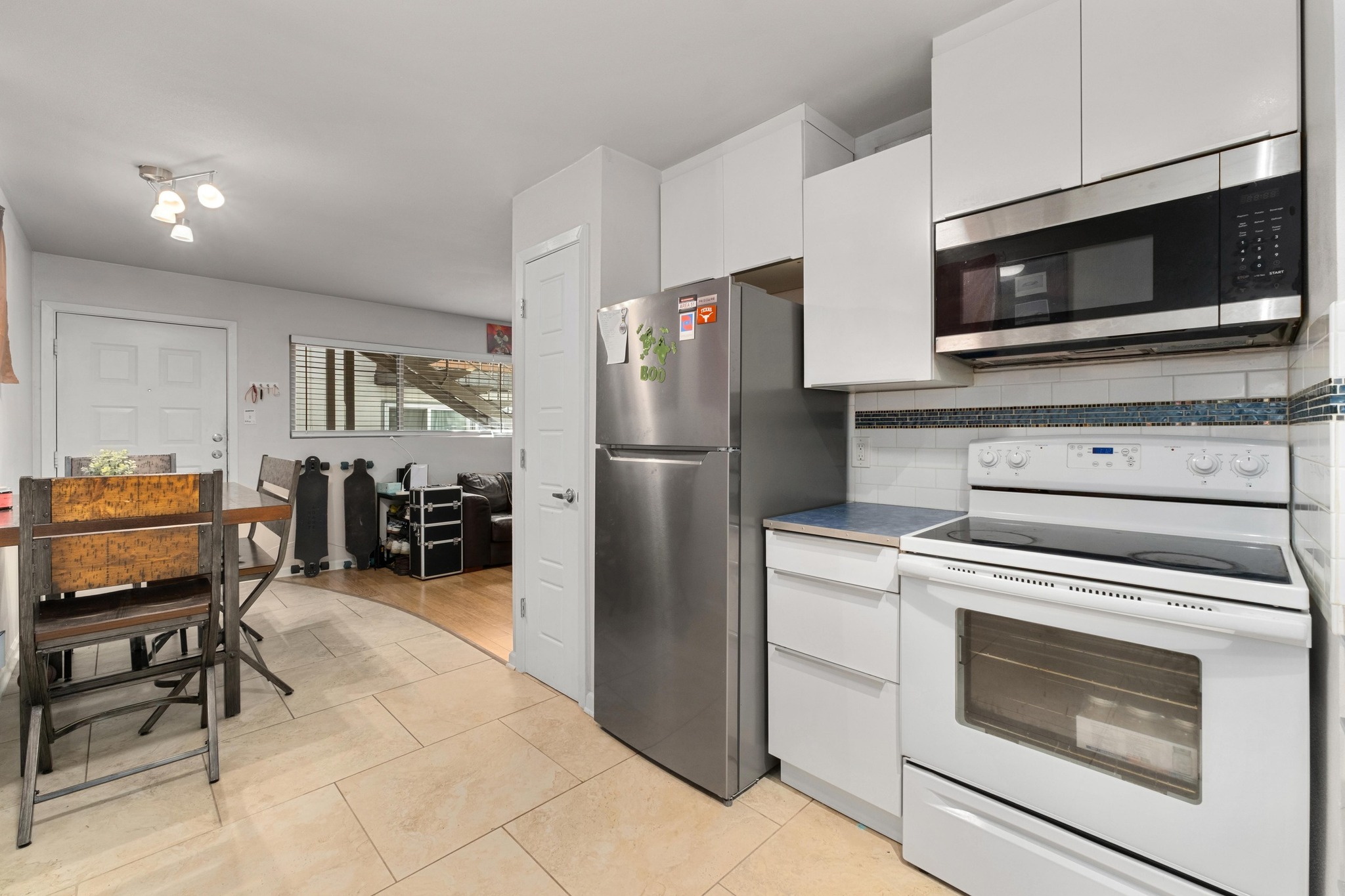 2404 Longview Street, Unit 105 Austin, TX 78705 - Photo 9 of 21 a kitchen with stainless steel appliances white cabinets and a stove top oven