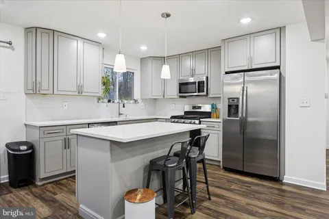 a kitchen with kitchen island a sink stove and refrigerator