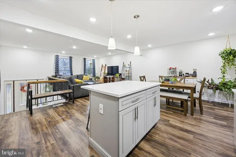 a kitchen with a stove a refrigerator and a dining table with wooden floor