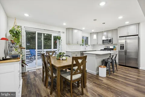 a kitchen with stainless steel appliances kitchen island granite countertop a dining table chairs and granite counter tops