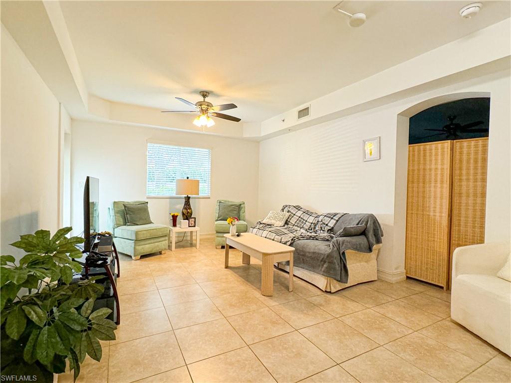 1100 Pine Ridge Road, Unit 105B Naples, FL 34108 - Photo 6 of 11 Tiled living room featuring a tray ceiling and ceiling fan