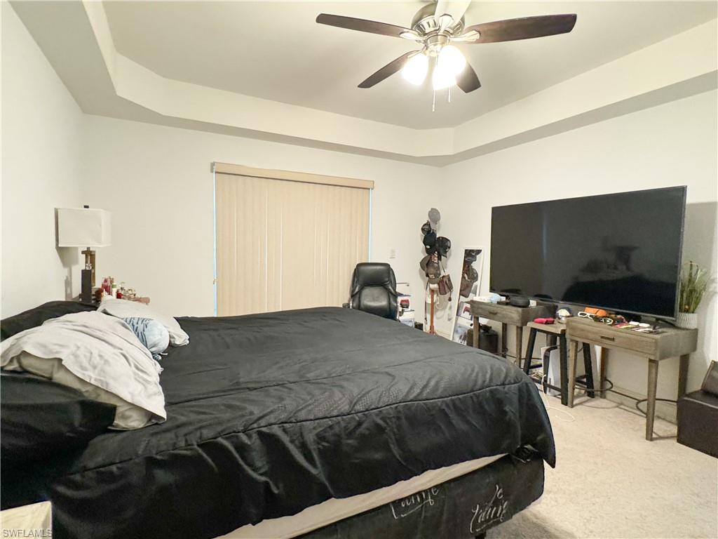 1100 Pine Ridge Road, Unit 105B Naples, FL 34108 - Photo 9 of 11 Bedroom with a tray ceiling, light colored carpet, and ceiling fan