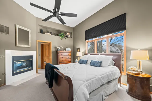 a bedroom with a balcony a bed and a fireplace