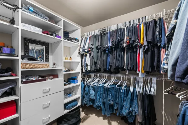 a view of walk in closet with clothes and shoes