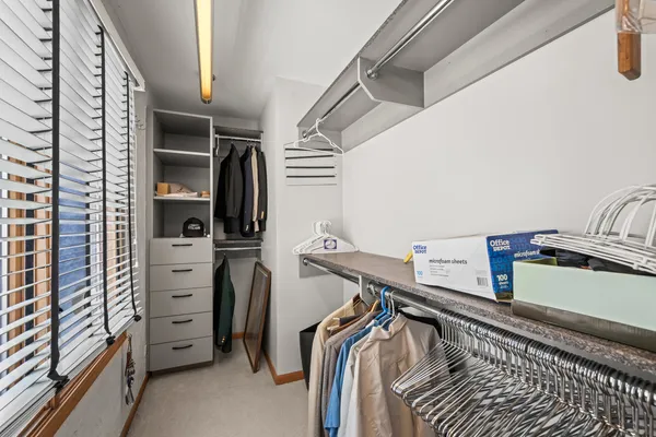 a view of walk in closet with clothes and shoes