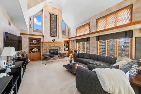 a living room with furniture a fireplace and a large window