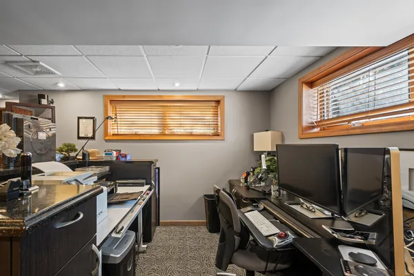 a view of a workspace with furniture and a window