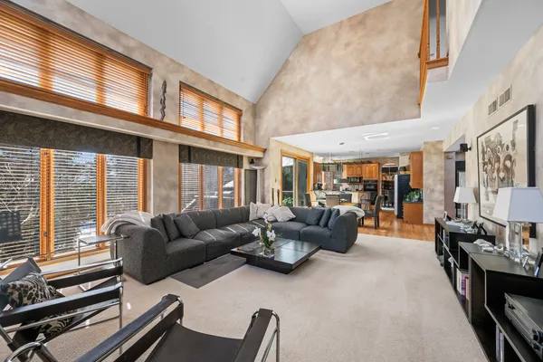 a living room with furniture fireplace and large windows