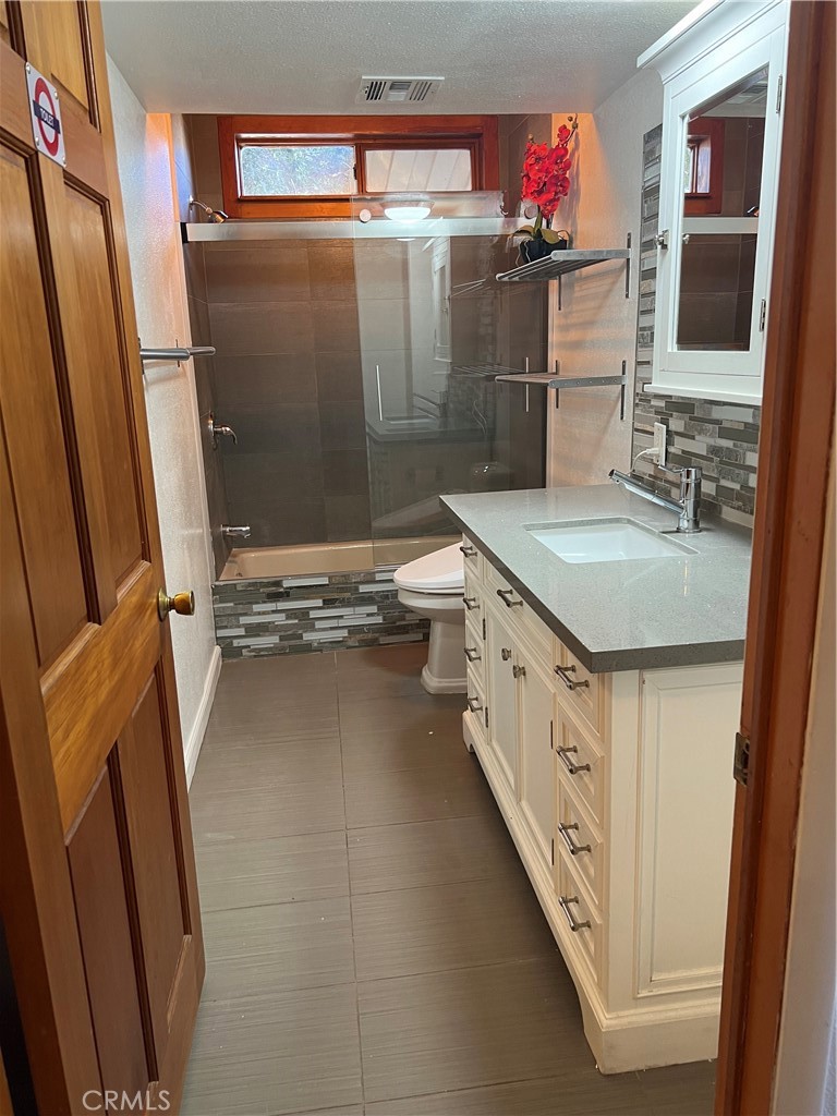 29716 Jackson Street Castaic, CA 91384 - Photo 28 of 38 a bathroom with a granite countertop sink a mirror and shower