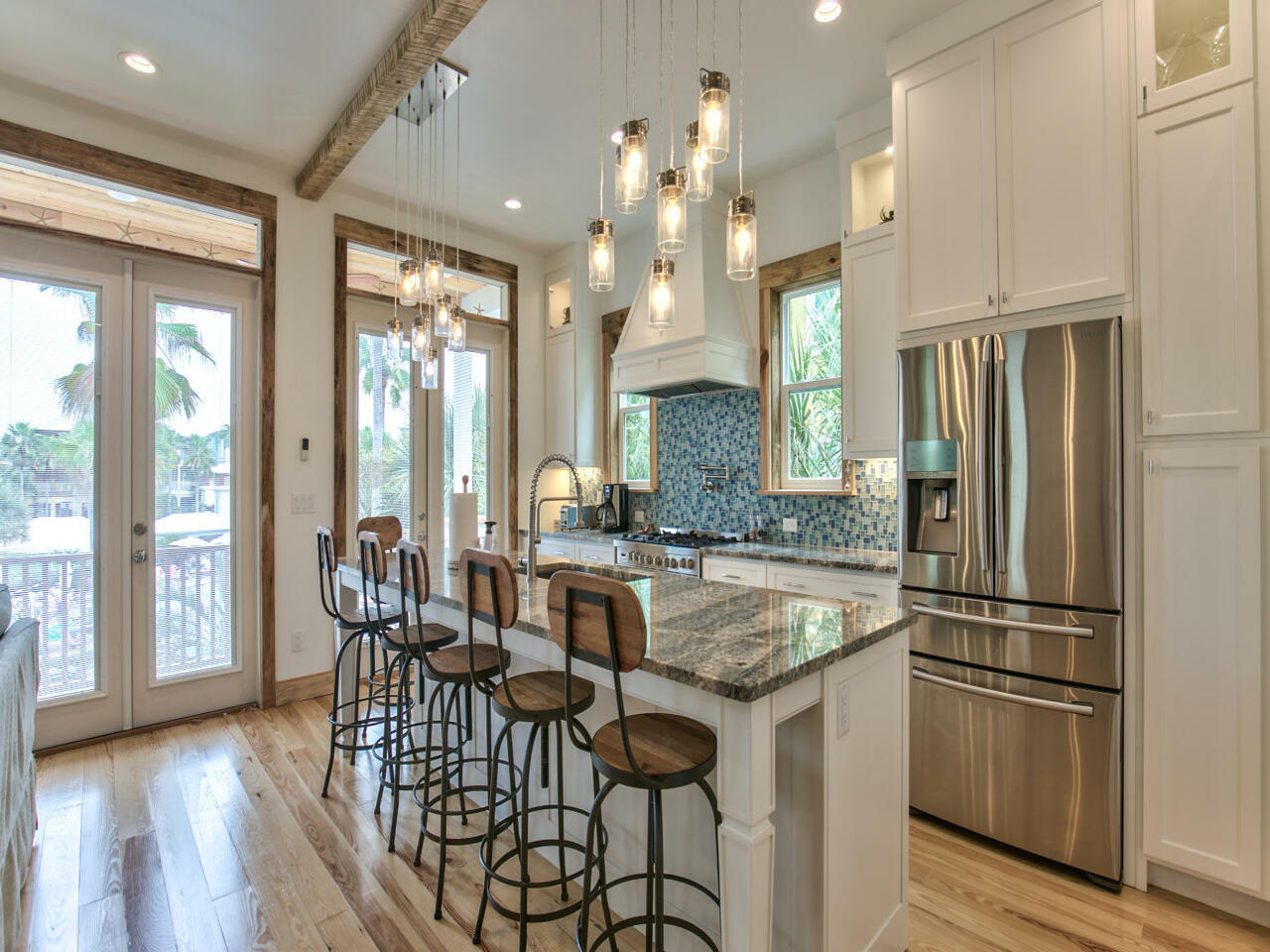 42 West Seacrest Beach Blvd Inlet Beach Inlet Beach, FL 32461 - Photo 22 of 52 a kitchen with stainless steel appliances granite countertop a refrigerator a sink a stove and white cabinets with wooden floor