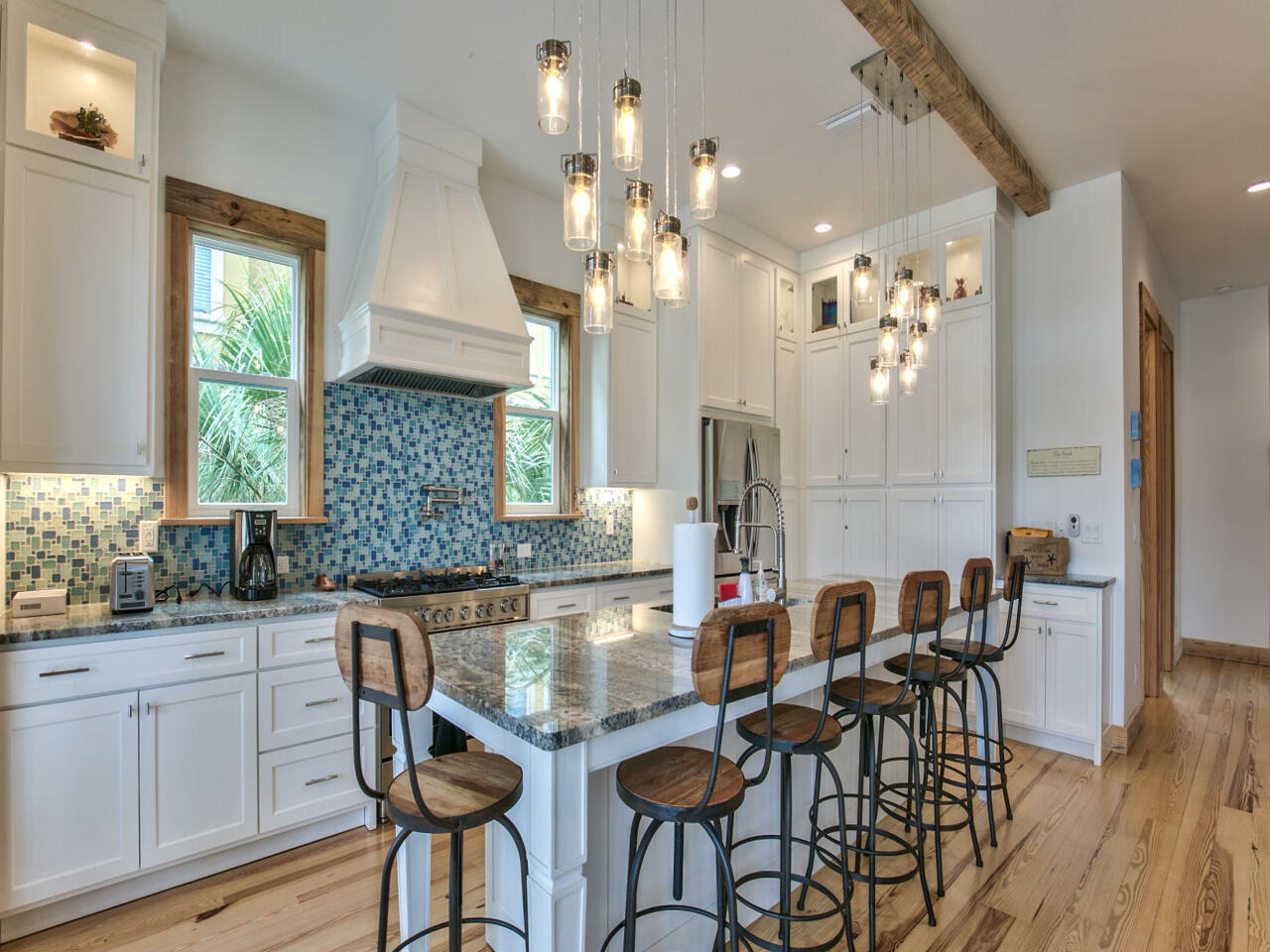 42 West Seacrest Beach Blvd Inlet Beach Inlet Beach, FL 32461 - Photo 27 of 52 a kitchen with granite countertop a dining table chairs and white cabinets