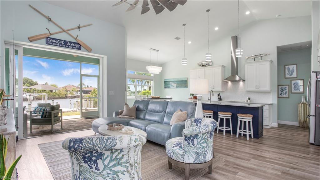 162 Windward Cay Naples, FL 34114 - Photo 2 of 35 a living room with furniture a wooden floor and a large window