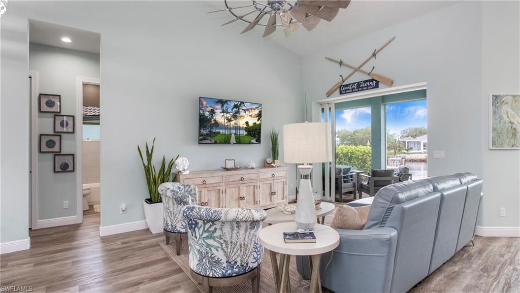 162 Windward Cay Naples, FL 34114 - Photo 3 of 35 a living room with furniture a chandelier and a flat screen tv