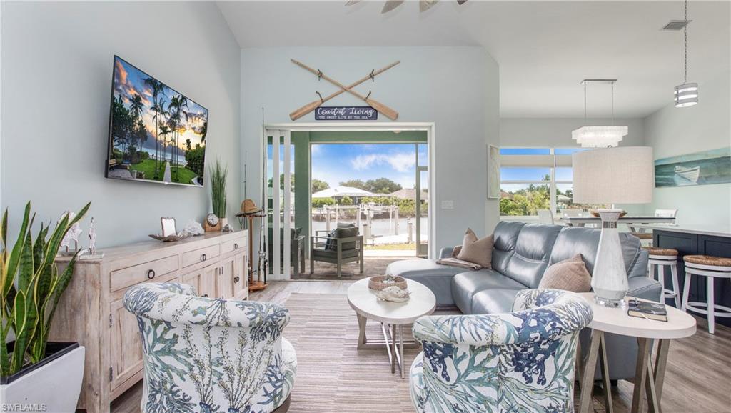 162 Windward Cay Naples, FL 34114 - Photo 4 of 35 a living room with furniture a flat screen tv and a large window
