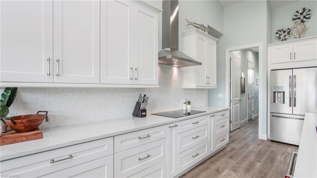 162 Windward Cay Naples, FL 34114 - Photo 8 of 35 a kitchen with white cabinets and refrigerator
