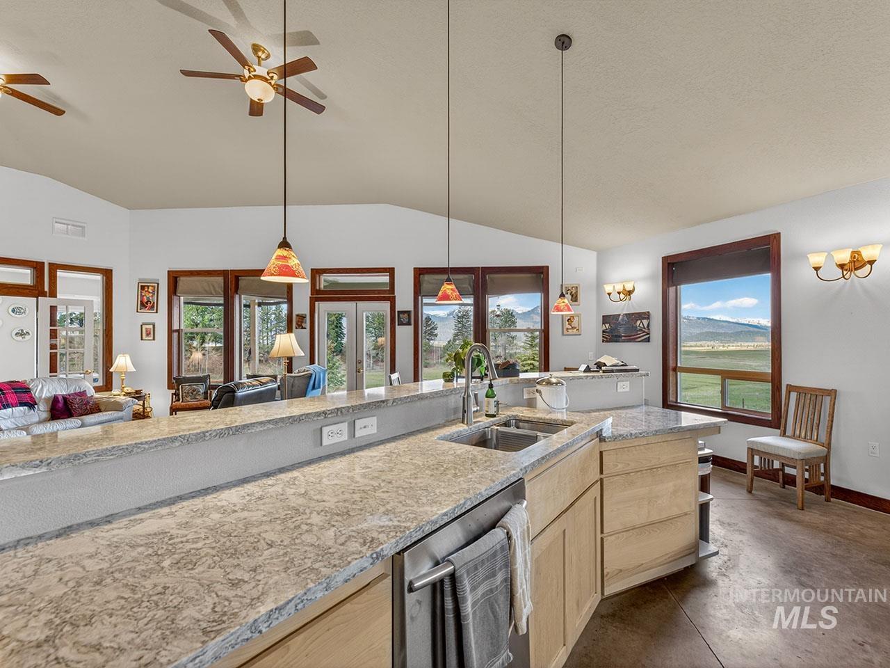 10885 Callender Road Cascade, ID 83611 - Photo 16 of 31 Kitchen island featuring a dual-basin stainless steel sink, pull-down faucet, and light-toned countertop