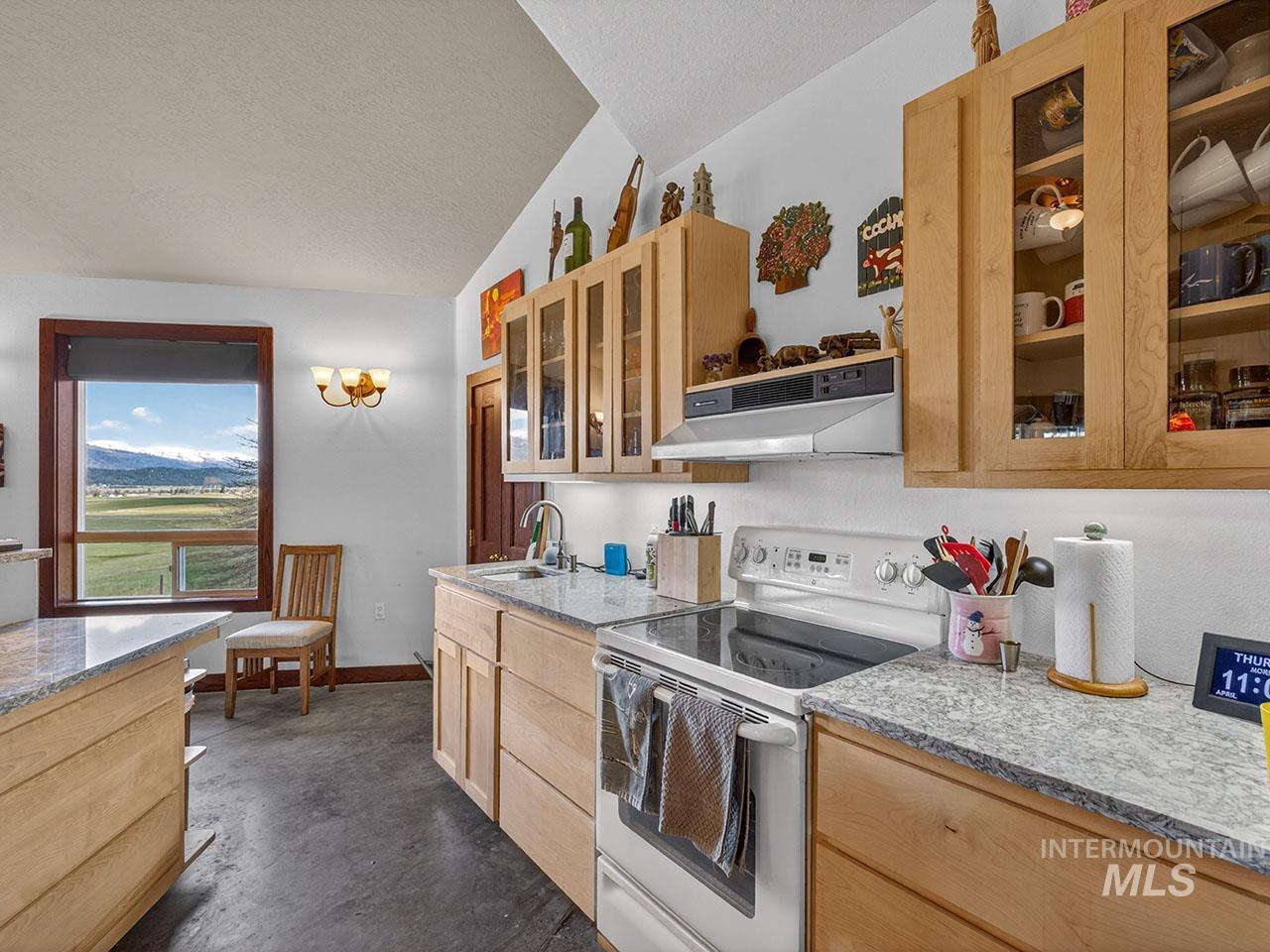 10885 Callender Road Cascade, ID 83611 - Photo 18 of 31 Kitchen featuring light wood cabinetry, light-toned countertops, and a white electric range