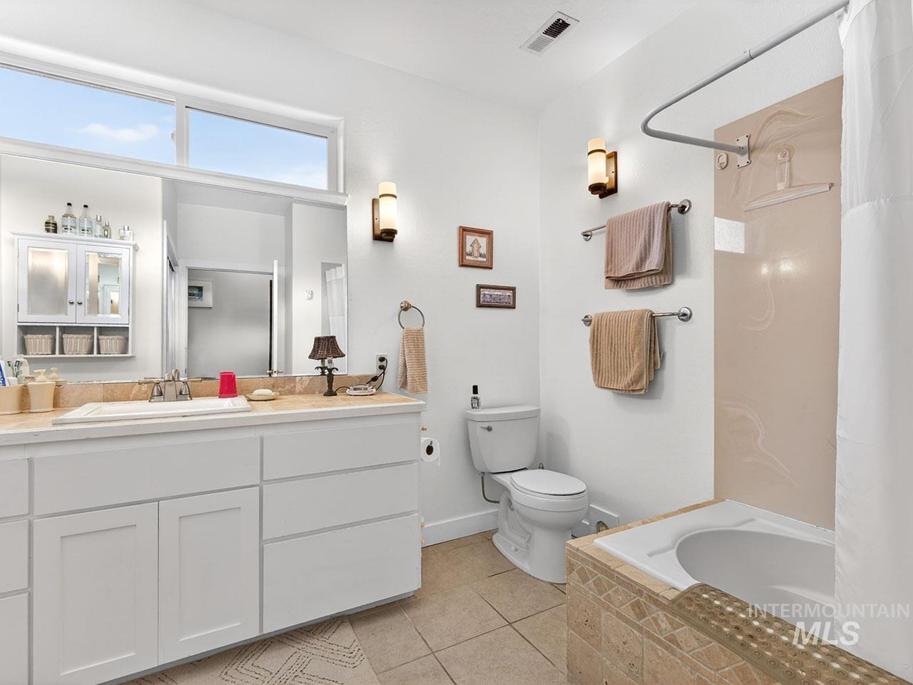 10885 Callender Road Cascade, ID 83611 - Photo 25 of 31 Bathroom featuring a white vanity with an integrated sink, a light-colored countertop, and a large mirror