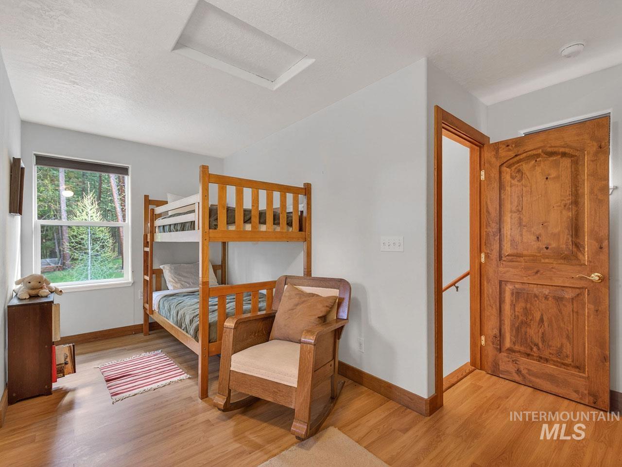 10885 Callender Road Cascade, ID 83611 - Photo 28 of 31 Room with wood-finish flooring, a window offering green landscape views, and a solid wood door