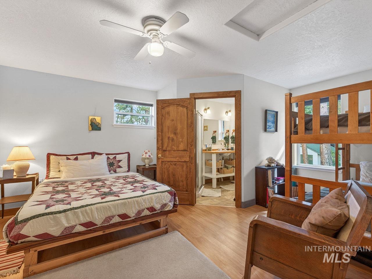 10885 Callender Road Cascade, ID 83611 - Photo 29 of 31 Spacious bedroom with wood-finish flooring, featuring a ceiling fan, a window, and a built-in bunk bed structure