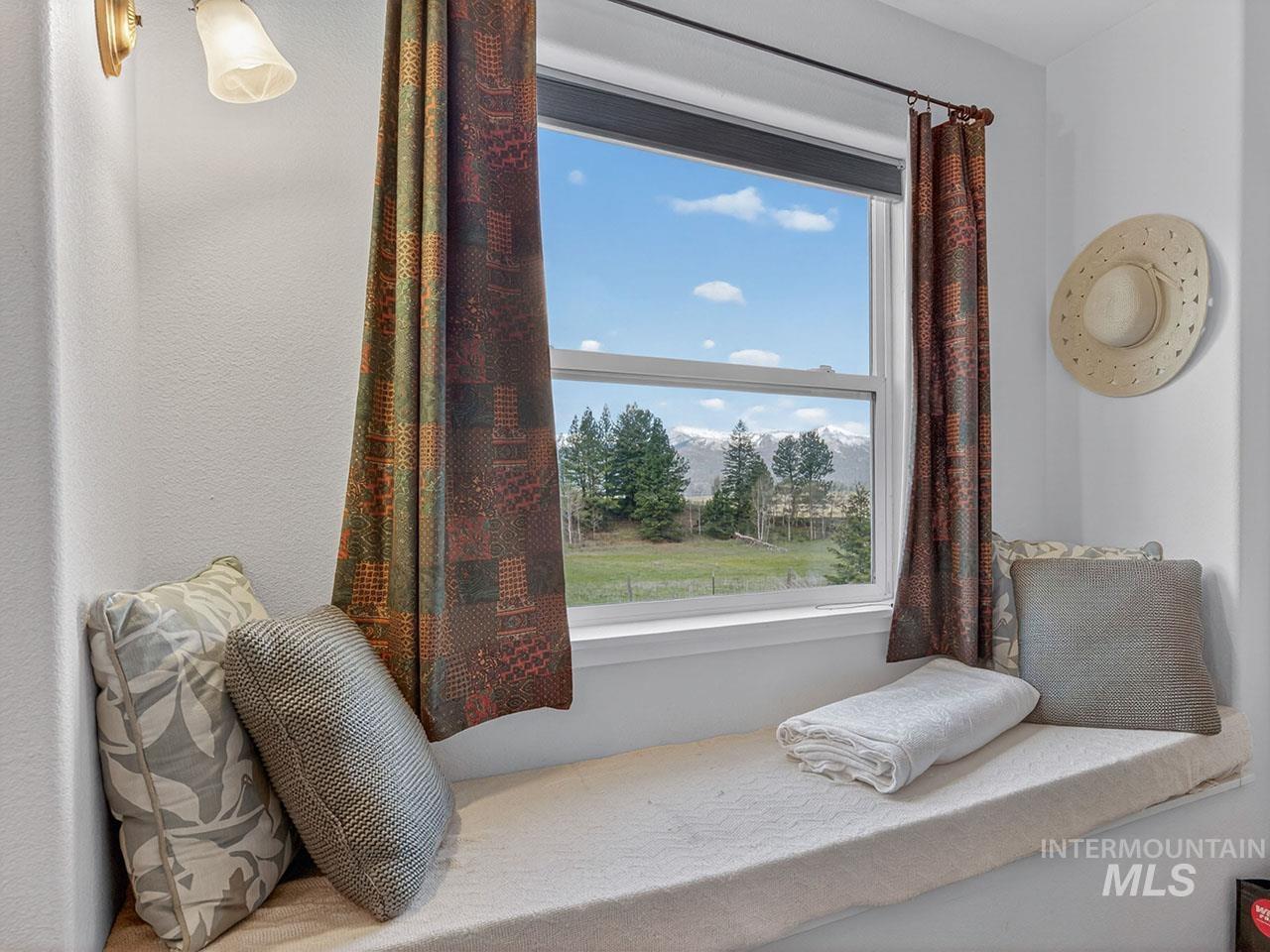 10885 Callender Road Cascade, ID 83611 - Photo 30 of 31 Built-in window seat featuring a cushioned surface, white trim, and views of distant mountains and open fields