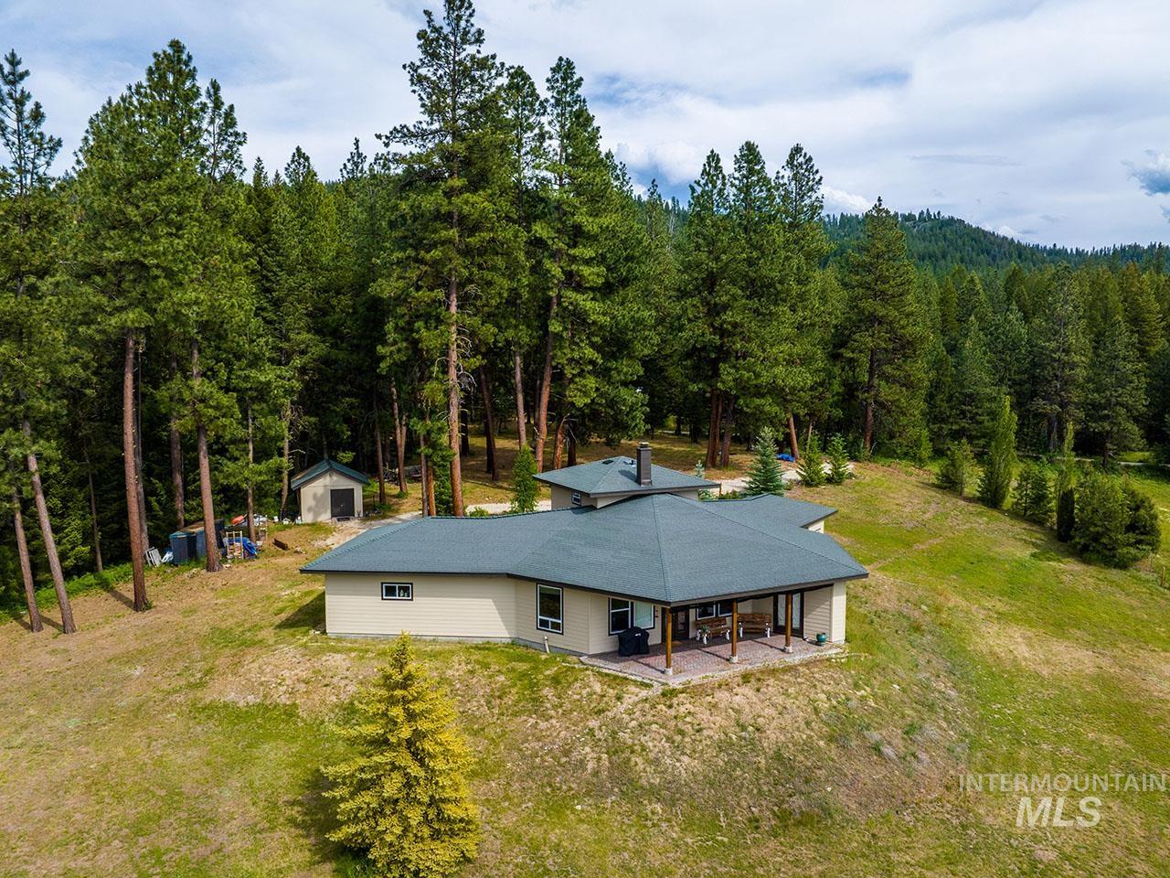 10885 Callender Road Cascade, ID 83611 - Photo 8 of 31 Spacious single-story residence featuring a covered patio, extensive surrounding natural landscape, and a secondary detached structure