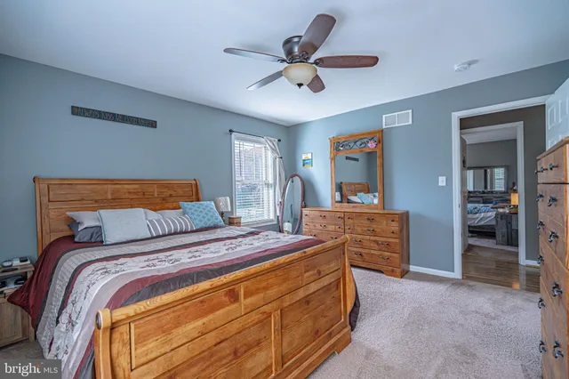a bathroom with a granite countertop sink a toilet a mirror and shower