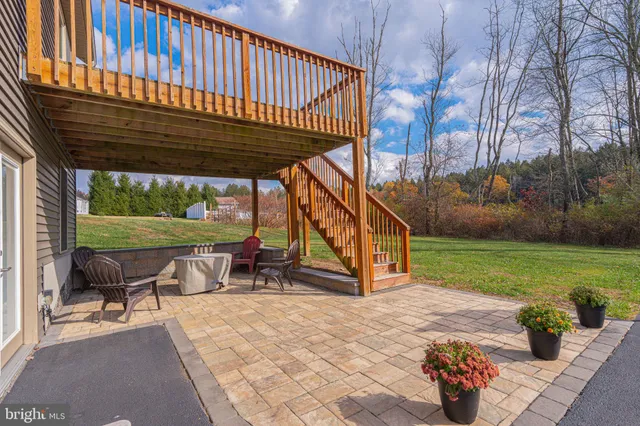 a view of a patio with table and chairs and couches with wooden floor and fence