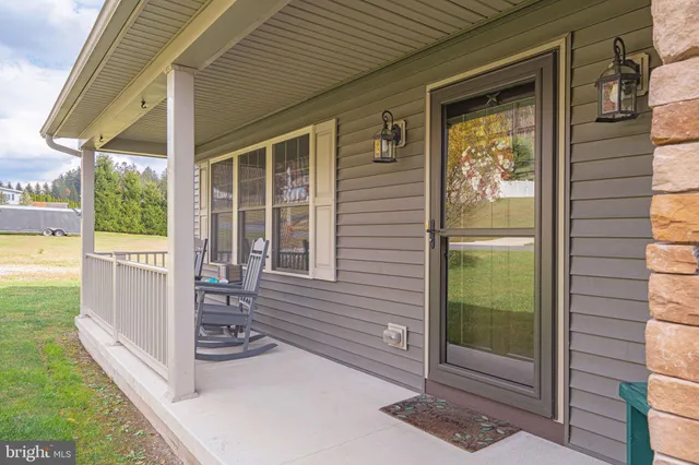 a living room with furniture a flat screen tv and kitchen view