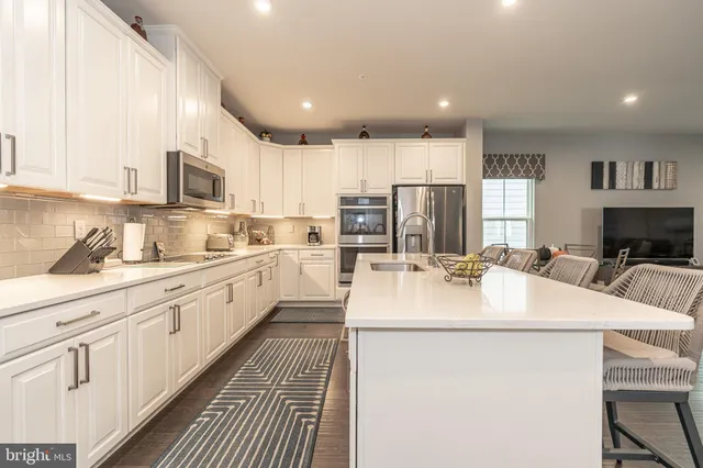 a kitchen with a refrigerator and white cabinets