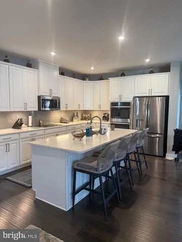 a large kitchen with a large counter top appliances and a dining table