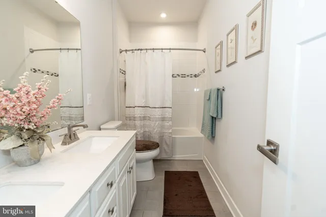 a bathroom with a toilet sink vanity and mirror