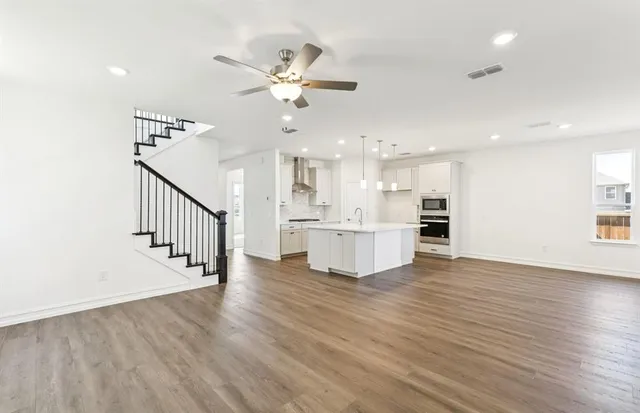 a view of kitchen with wooden floor and electronic appliances