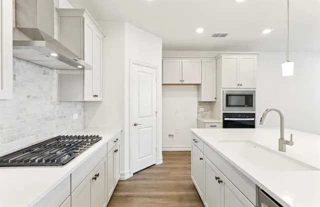 a kitchen with sink a stove and cabinets