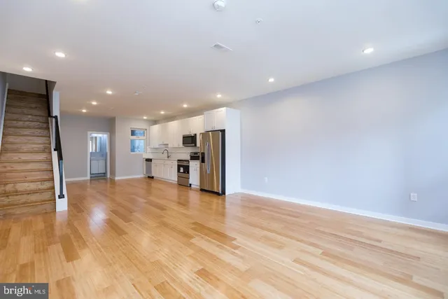 a view of empty room with wooden floor