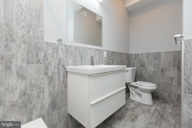 a bathroom with a sink a toilet and a mirror