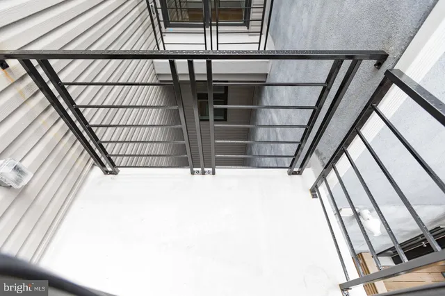 a view of staircase with wooden floor and white walls
