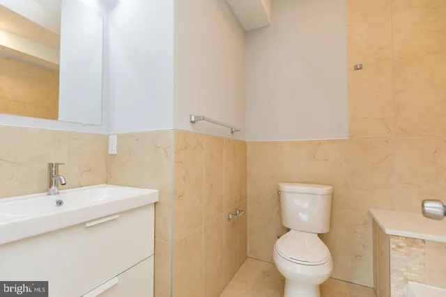 a bathroom with a sink a toilet and a mirror